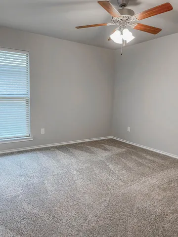 an empty room with a chandelier fan