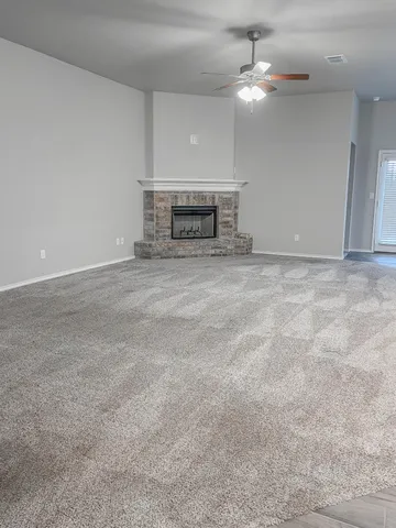 a view of a livingroom with a chandelier fan and a fireplace