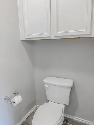 a white toilet sitting next to a window