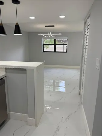 a large kitchen with stainless steel appliances a large counter top