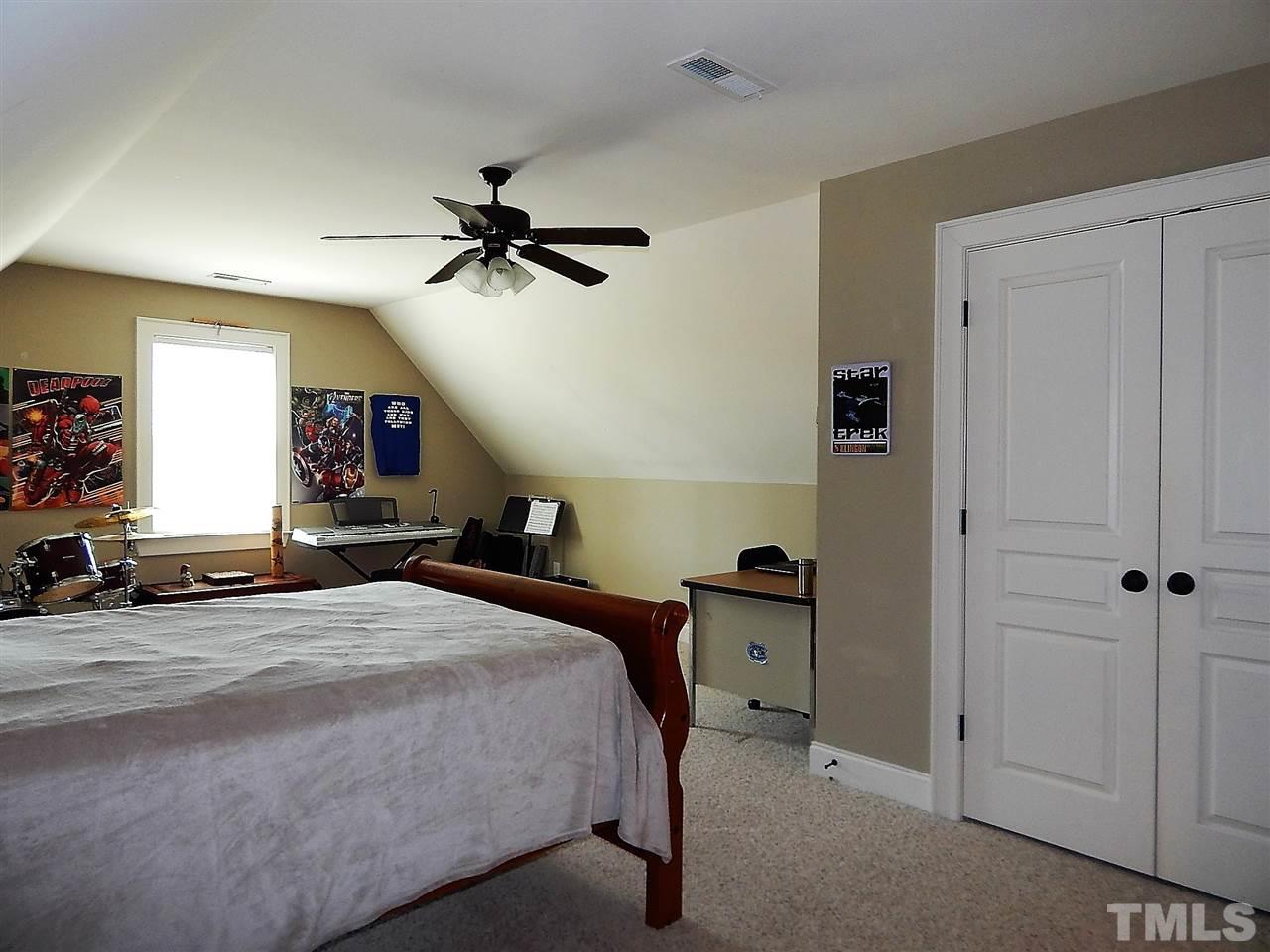 32 North Sunset Ridge Drive Willow Spring, NC 27592 - Photo 15 of 25 a bedroom with a bed and a chandelier