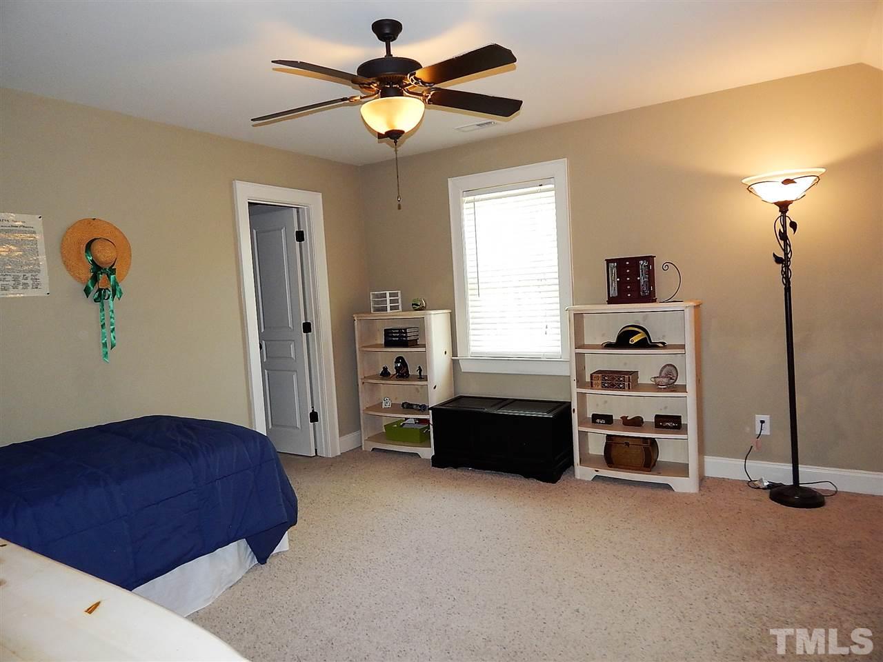 32 North Sunset Ridge Drive Willow Spring, NC 27592 - Photo 16 of 25 a bedroom with a bed and a chandelier