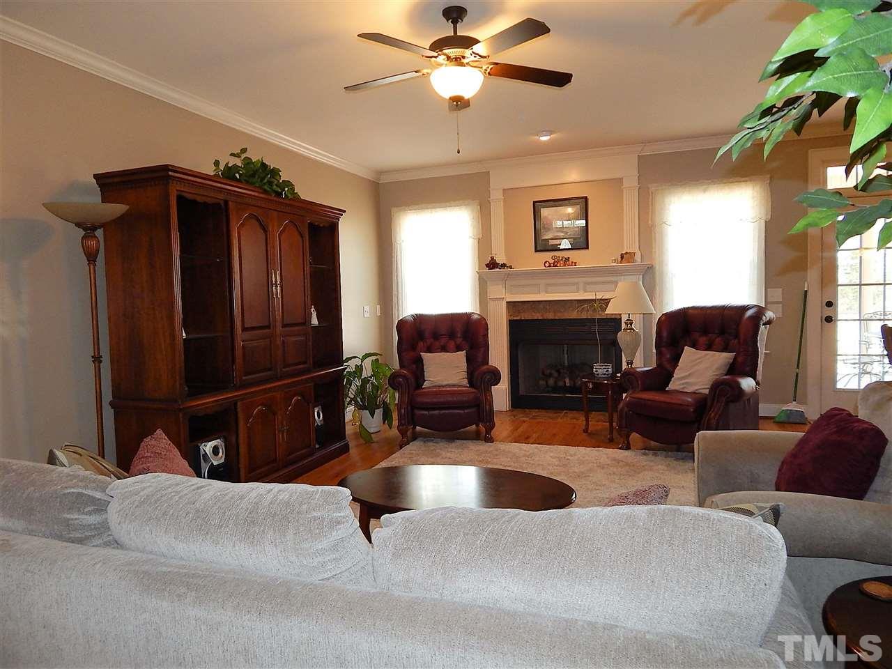 32 North Sunset Ridge Drive Willow Spring, NC 27592 - Photo 5 of 25 a living room with furniture a fireplace and a flat screen tv