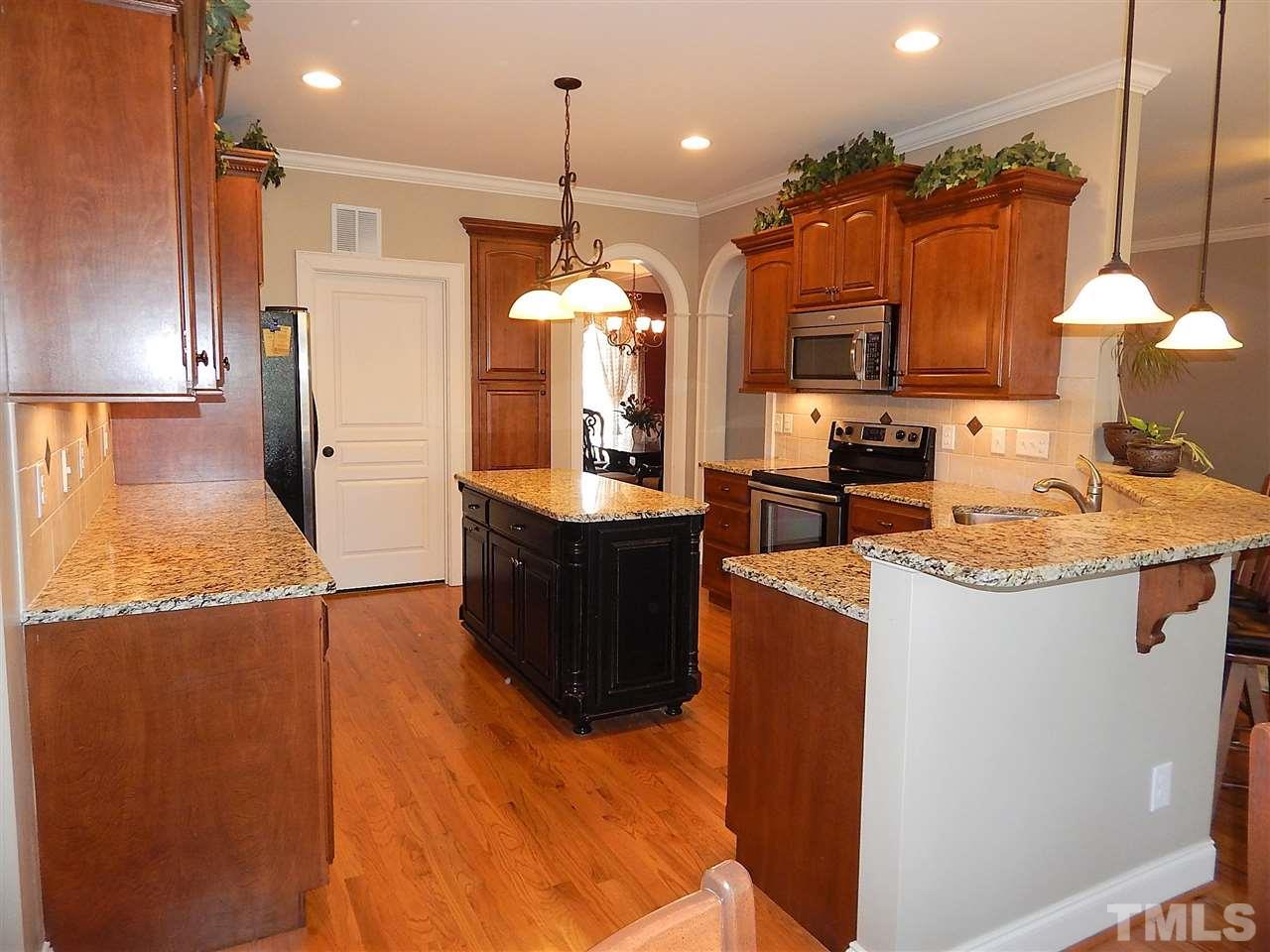 32 North Sunset Ridge Drive Willow Spring, NC 27592 - Photo 7 of 25 a kitchen with stainless steel appliances kitchen island granite countertop a sink and a refrigerator