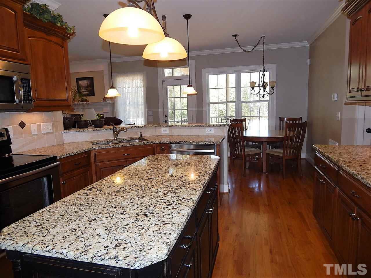 32 North Sunset Ridge Drive Willow Spring, NC 27592 - Photo 8 of 25 a kitchen with stainless steel appliances granite countertop wooden floor a stove top oven a sink dishwasher and cabinets with wooden floor