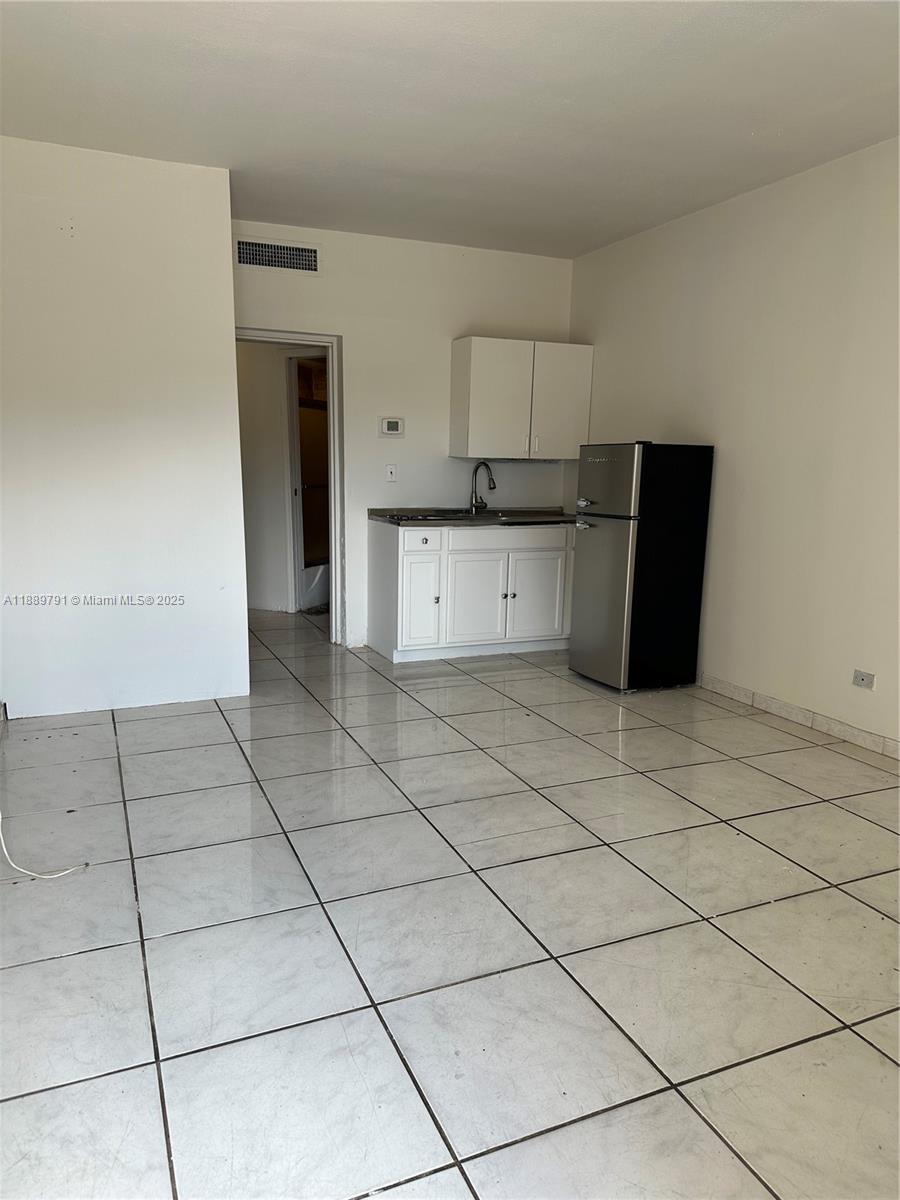 26 Diplomat Parkway, Unit 2248 Hallandale Beach, FL 33009 - Photo 3 of 8 a kitchen with cabinets and a stove top oven