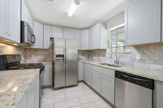 a kitchen with stainless steel appliances granite countertop a stove and a microwave