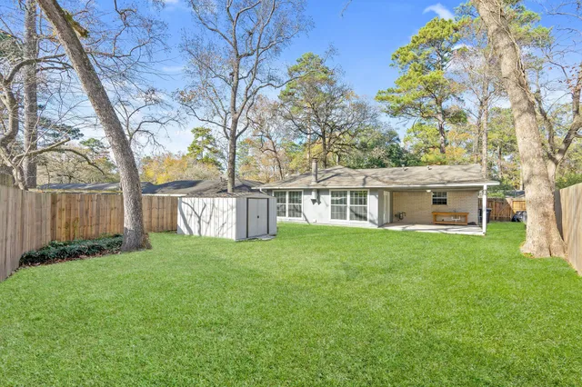 a view of a house with a yard and a tree