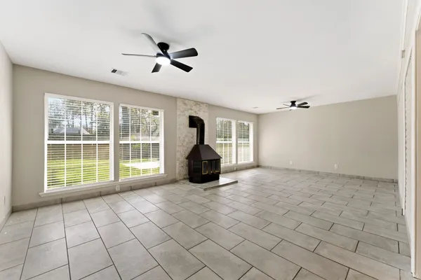 an empty room with windows and ceiling fan