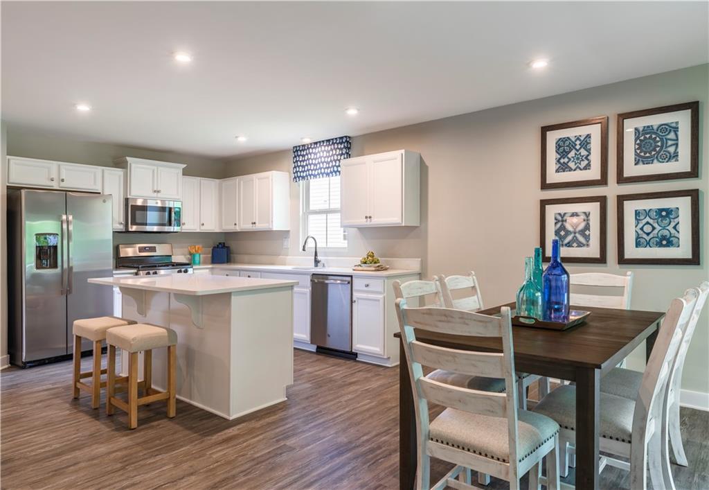 844 Ashley Road Gibsonia, PA 15044 - Photo 8 of 16 a kitchen with a dining table chairs refrigerator and cabinets