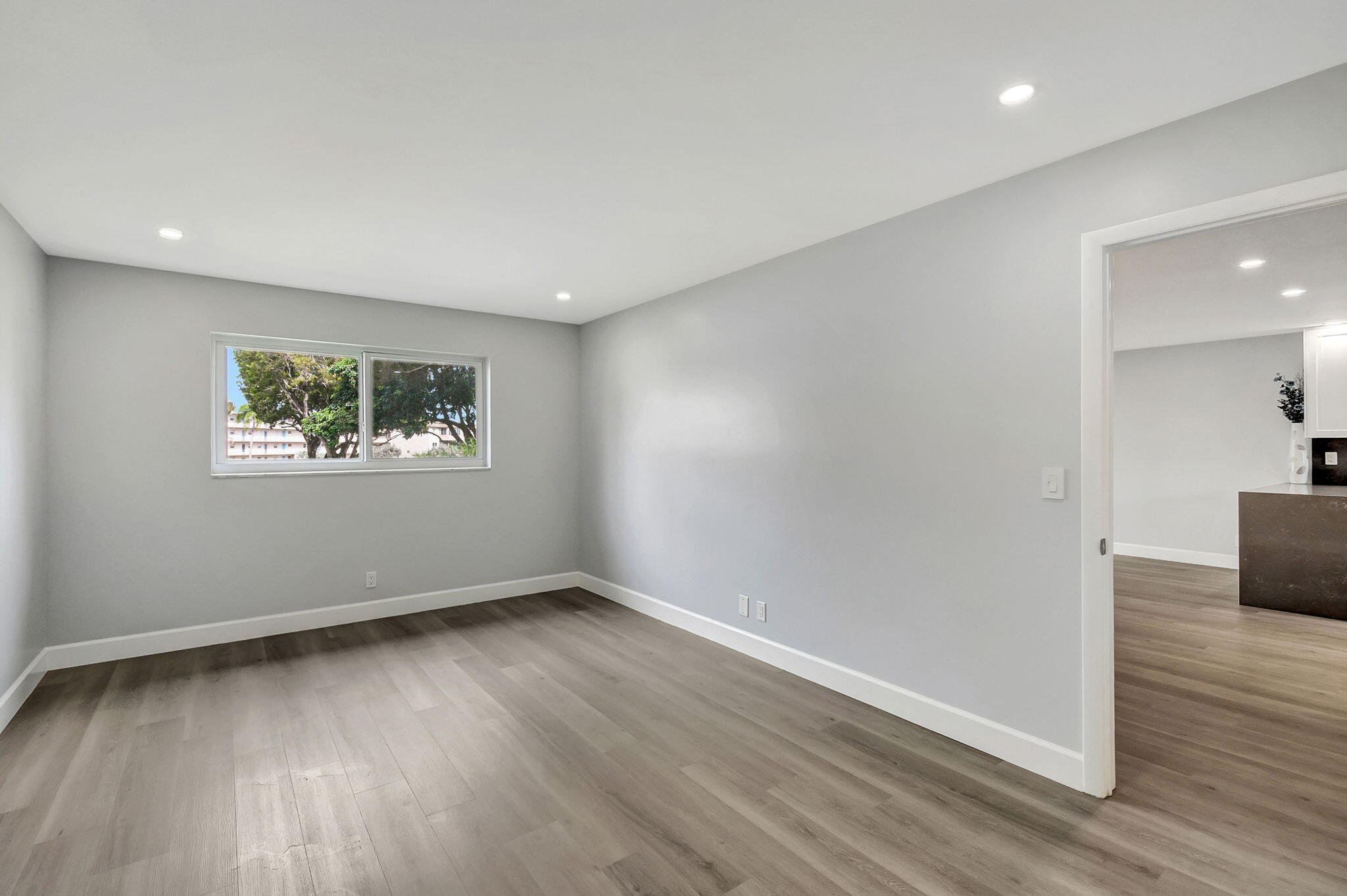 702 Lori Drive, Unit 194 Palm Springs, FL 33461 - Photo 14 of 41 a view of an empty room with wooden floor and a window
