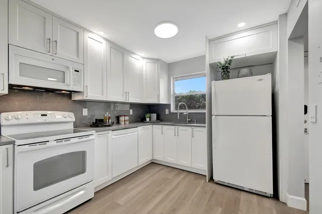 a kitchen with white cabinets and white appliances