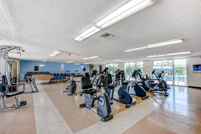 a view of a room with gym equipment and large mirror