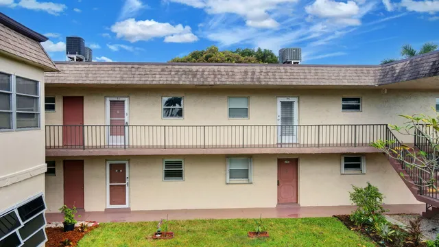 a view of a house with wooden deck and furniture