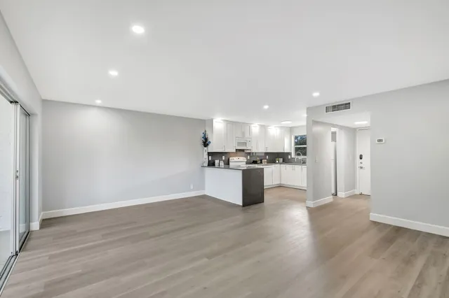 a view of kitchen refrigerator and wooden floor