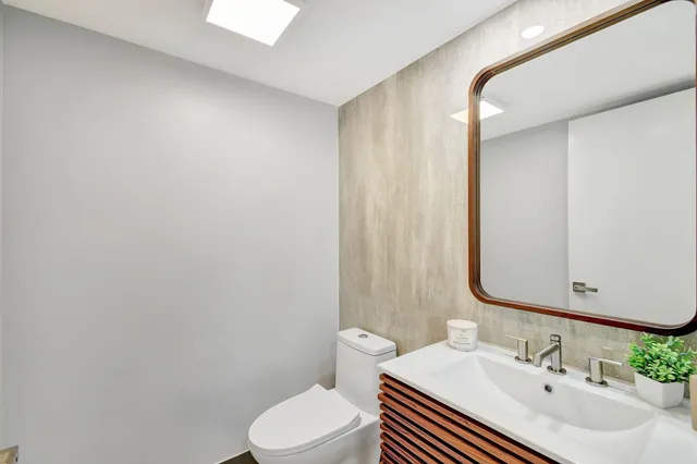 a bathroom with a sink a toilet and mirror