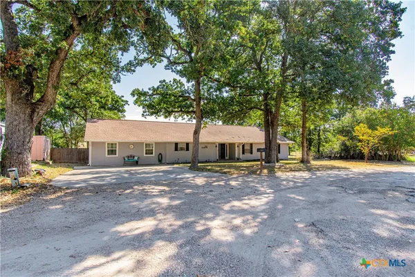 a view of a house with a tree next to a road
