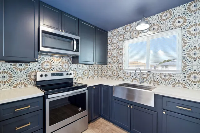 a kitchen with stainless steel appliances a sink stove and microwave