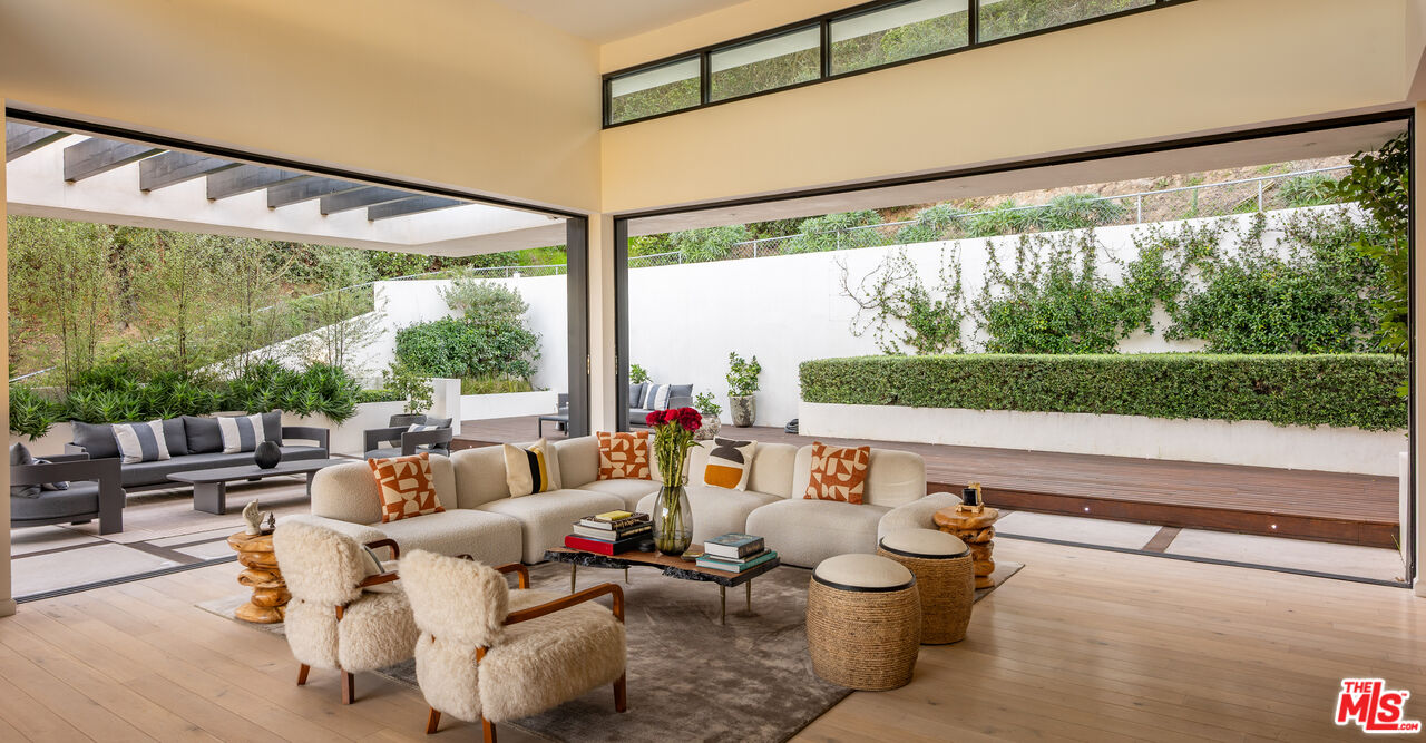 a living room with patio furniture and a large window