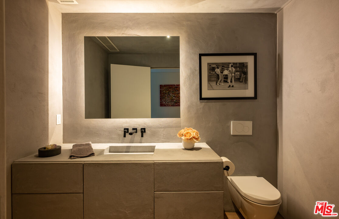 7681 Willow Glen Road Los Angeles, CA 90046 - Photo 27 of 71 a bathroom with a toilet sink vanity and mirror