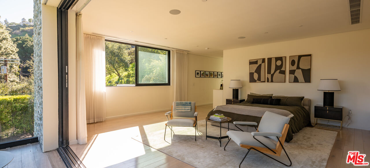 7681 Willow Glen Road Los Angeles, CA 90046 - Photo 38 of 71 a bedroom with a bed and wooden floor