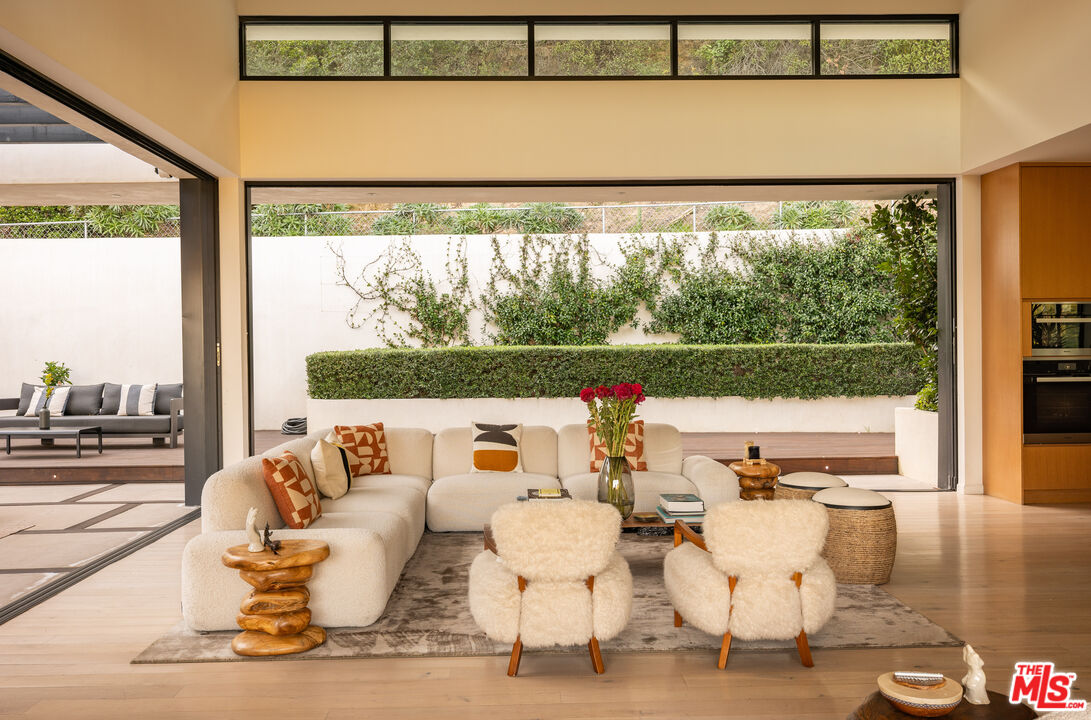 7681 Willow Glen Road Los Angeles, CA 90046 - Photo 7 of 71 a living room with couches and a large window with garden view