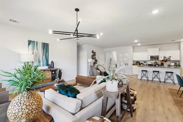 a living room with furniture a potted plant and a kitchen view