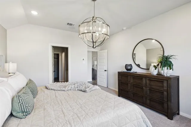 a bedroom with a bed and a chandelier