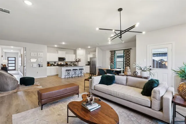 a living room with furniture a rug and kitchen view