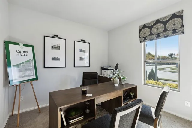 a view of a workspace with furniture and a window