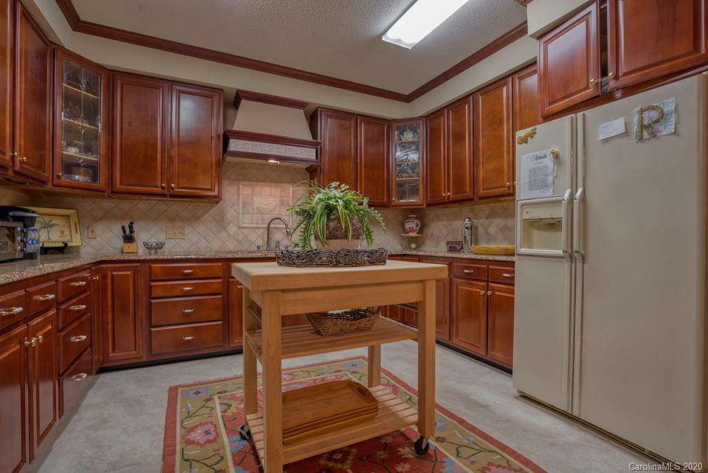 77 Club Road Tryon, NC 28782 - Photo 17 of 35 a kitchen with stainless steel appliances granite countertop wooden cabinets a refrigerator a sink and a stove