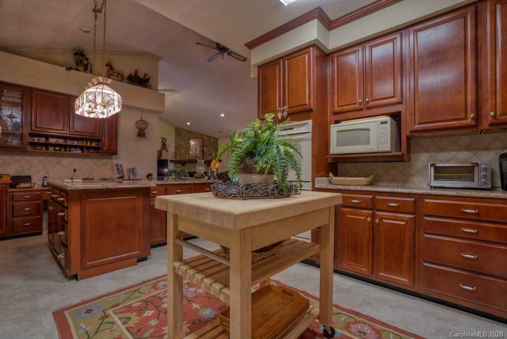 77 Club Road Tryon, NC 28782 - Photo 19 of 35 a kitchen with stainless steel appliances granite countertop a stove a sink dishwasher and a refrigerator with wooden floor