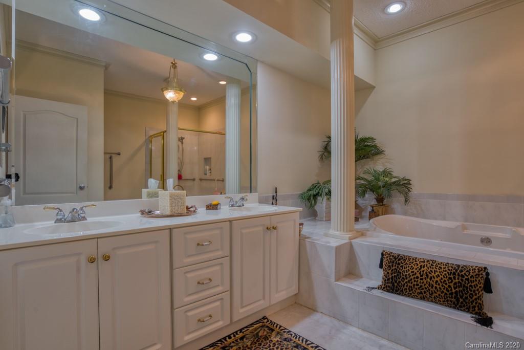 77 Club Road Tryon, NC 28782 - Photo 23 of 35 a spacious bathroom with a granite countertop sink a mirror and a bathtub
