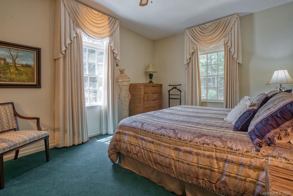 77 Club Road Tryon, NC 28782 - Photo 31 of 35 a bedroom with a bed and a chandelier