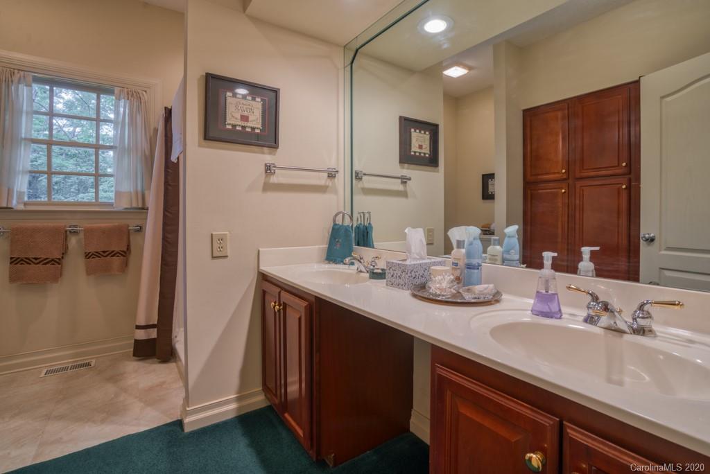 77 Club Road Tryon, NC 28782 - Photo 33 of 35 a bathroom with a sink double vanity granite and a mirror
