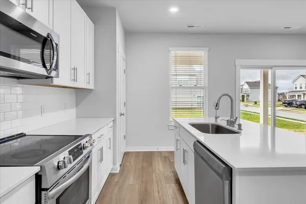 a kitchen with stainless steel appliances granite countertop a sink and a stove