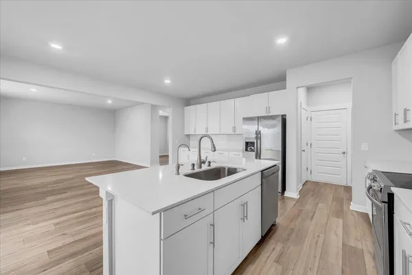 a kitchen with white cabinets sink and stainless steel appliances