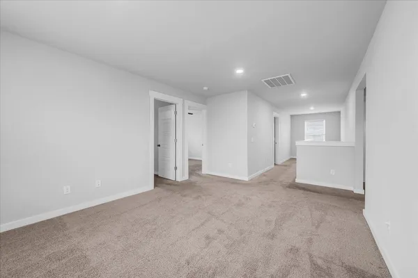 an empty room with windows and ceiling fan