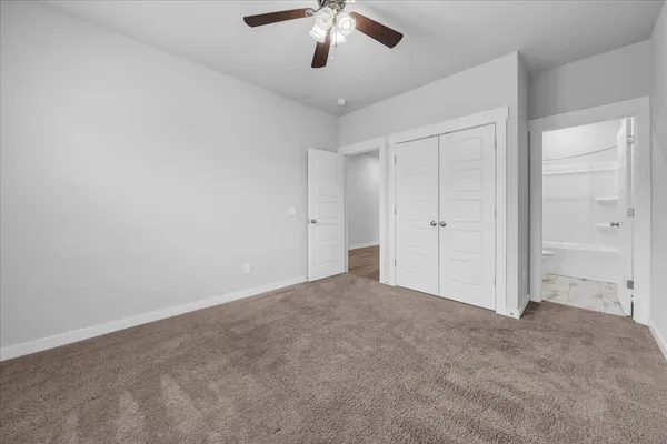 an empty room with chandelier fan