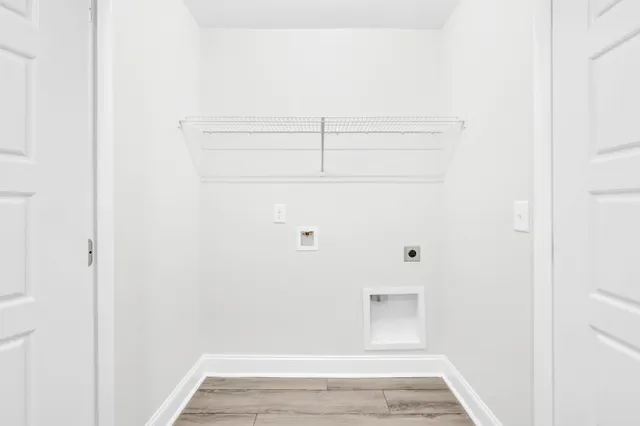 an empty room with wooden floor windows and fan