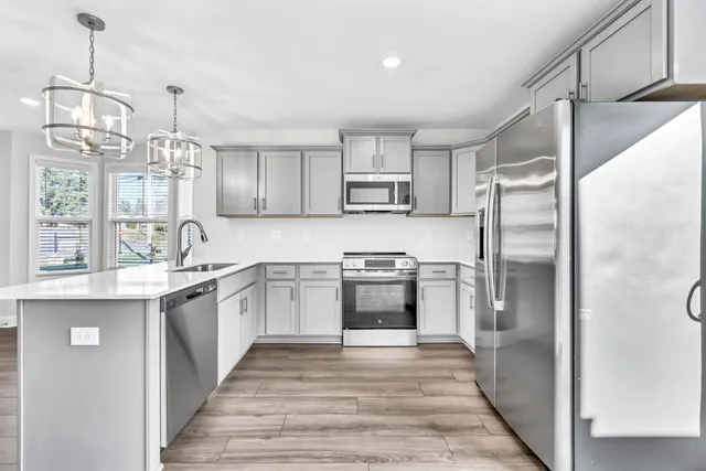 a kitchen with kitchen island white cabinets and stainless steel appliances