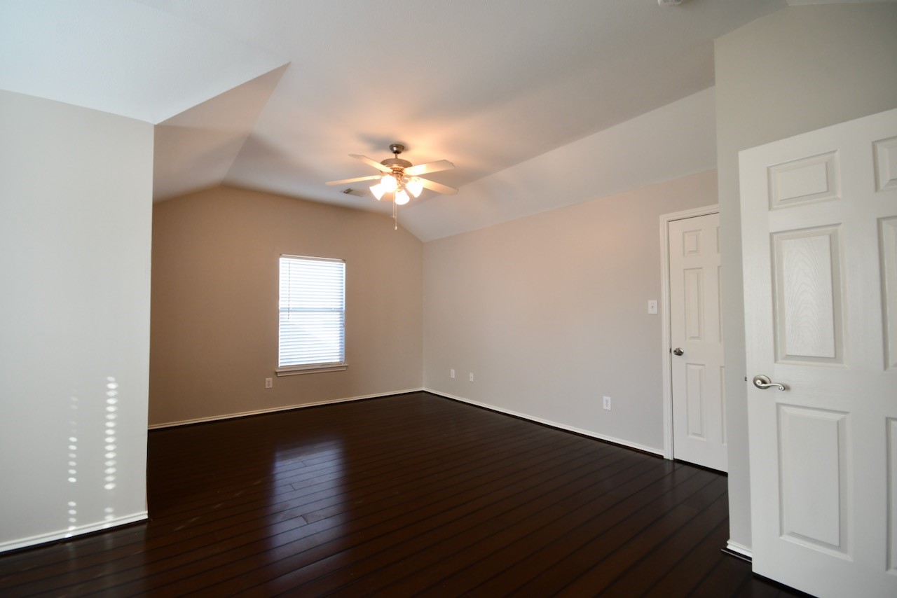1706 Redwing Bluff Drive Houston, TX 77009 - Photo 12 of 24 an empty room with wooden floor and windows