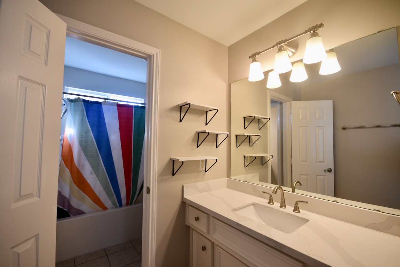 1706 Redwing Bluff Drive Houston, TX 77009 - Photo 18 of 24 a bathroom with a sink a large mirror and a shower