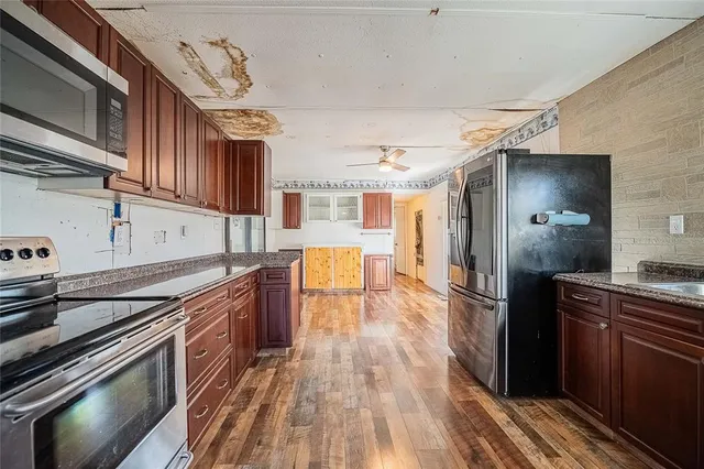 a kitchen with granite countertop stainless steel appliances and wooden cabinets