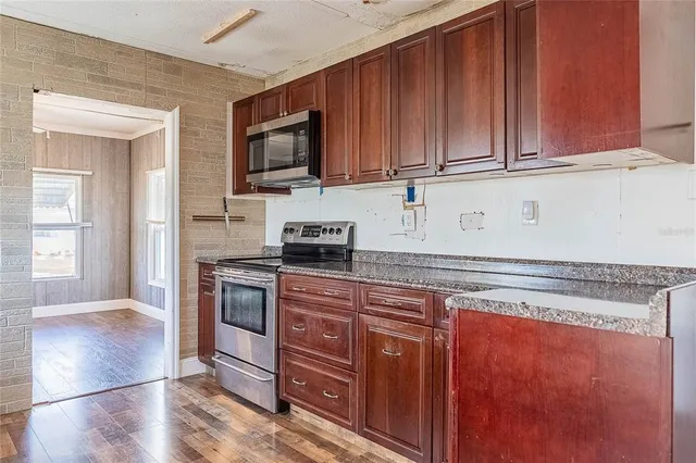 a kitchen with stainless steel appliances granite countertop wooden cabinets a stove top oven a sink and dishwasher