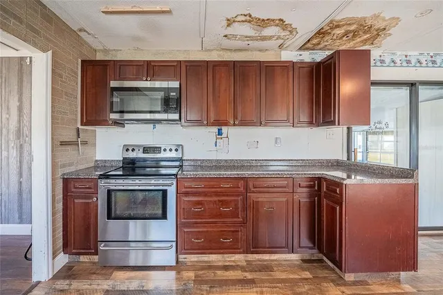 a kitchen with stainless steel appliances wooden cabinets and a stove top oven