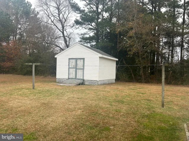 a view of backyard of house and trees in the background