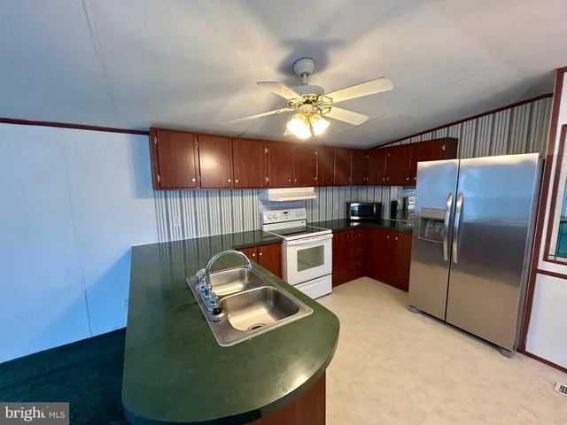 a kitchen with cabinets a refrigerator and a fireplace