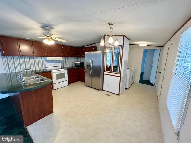 a open kitchen with refrigerator stove microwave and cabinets