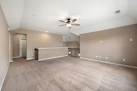 wooden floor in an empty room with a ceiling fan